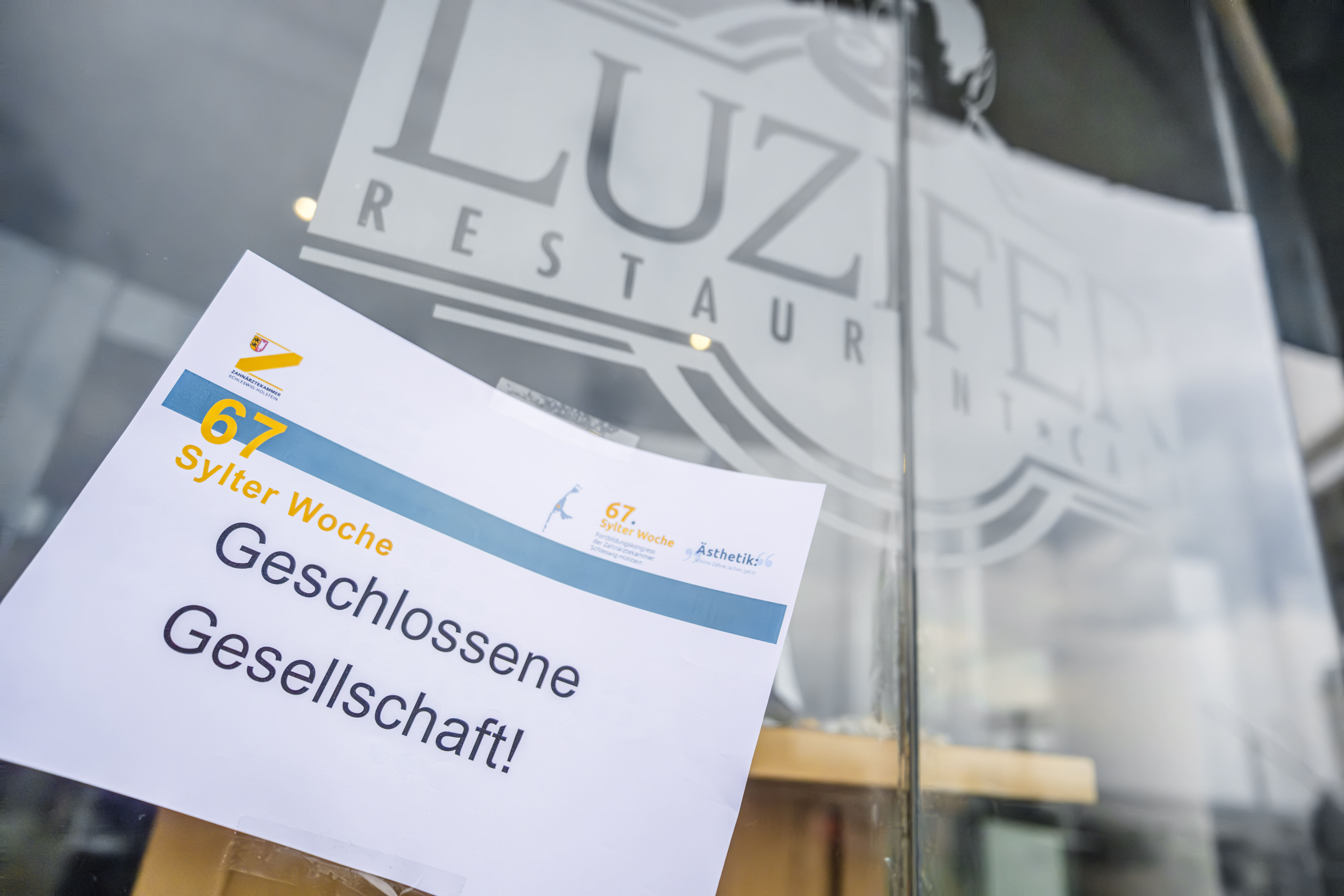 Auf einem Schild an einer Glastür steht 